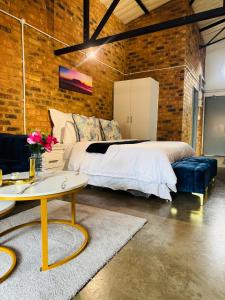 ein Schlafzimmer mit einem Bett und einer Ziegelwand in der Unterkunft Blue Haven on Craftmanship Hotel with WiFi Pool & Parking in Johannesburg