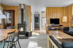 een woonkamer met een bank en een tafel met een open haard bij LF407-Hurup-Thy-Nattergalevej-7 in Sønder Ydby