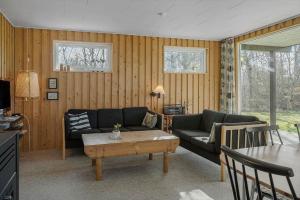 een woonkamer met een bank en een tafel bij LF407-Hurup-Thy-Nattergalevej-7 in Sønder Ydby +24 foto's