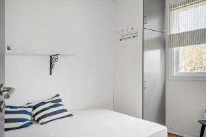 een witte slaapkamer met een bed en een raam bij LF407-Hurup-Thy-Nattergalevej-7 in Sønder Ydby