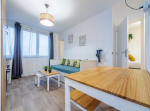 ein Wohnzimmer mit einem blauen Sofa und einem Tisch in der Unterkunft The Paris 9th Sky - 8min to Paris in Saint-Denis + 6 Fotos