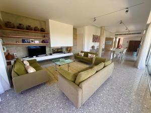 Luxury Villa Pluto Stunning Mountain Views في Ora: غرفة معيشة بها كنبتين وطاولة زجاجية