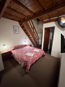 Un dormitorio con una cama con un edredón rojo. en Hotel Ibiza, en Villa Gesell 101 fotos más