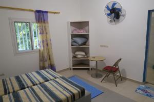 ein Schlafzimmer mit einem Bett und einem Tisch und einem Fenster in der Unterkunft Chez Fatou et Saladin in Diana + 24 Fotos