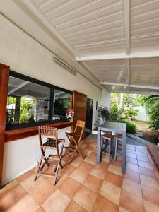 Un comedor con mesa y sillas en un patio. en Villa Patio Colibri, en Chambort