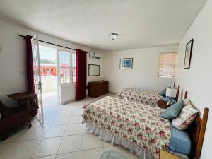 a bedroom with two beds and a balcony at 1B Hastings Towers in Bridgetown