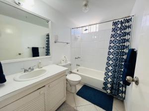 a bathroom with a sink and a toilet and a mirror at 1B Hastings Towers in Bridgetown