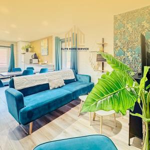 Suite Maëlle - Évasion & Confort في براي دون: غرفة معيشة مع أريكة زرقاء وكراسي زرقاء