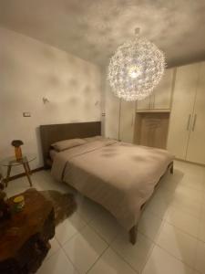 una camera da letto con un letto grande e un lampadario di Appartamento Catalina a Saint-Pierre