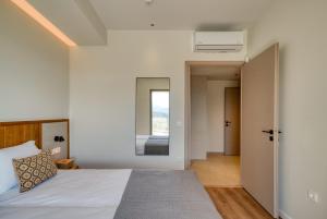 un dormitorio con una cama y un espejo en AnNiko Suites Nafplio, en Nauplia