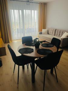 a living room with a table and chairs and a couch at Słoneczny Apartament Karpicko in Karpicko