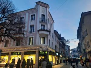een groep mensen die door een straat voor een gebouw lopen bij Le Cosy Center in Thonon-les-Bains