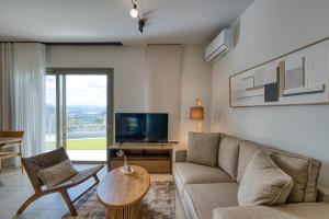 Una sala de estar con un sofá y un televisor. en AnNiko Suites Nafplio, en Nauplia 49 fotos más