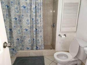 a bathroom with a toilet and a shower curtain at 1B Hastings Towers in Bridgetown +9 photos