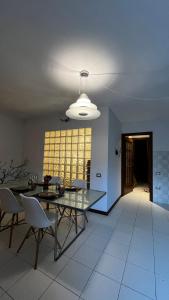 een eetkamer met een glazen tafel en witte stoelen bij Appartamento Catalina in Saint-Pierre