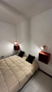 een slaapkamer met een groot bed met 2 lampen erop bij Appartamento Catalina in Saint-Pierre