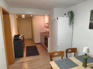 a kitchen with a white refrigerator and a table with a table sidx sidx at FeWo Hospitalskapelle in Schwalmstadt