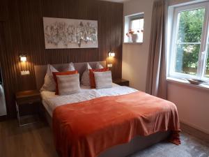 a bedroom with a bed with an orange blanket at Schafberg Luxury Apartment in St. Wolfgang
