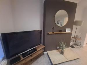 a living room with a large television and a mirror at Marsden Modern 3 Bed in South Shields