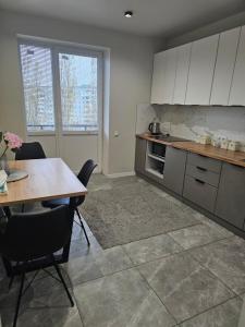 a kitchen with a table and a table and chairs at Сучасна квартира в новобудові біля луцького кільця in Rivne