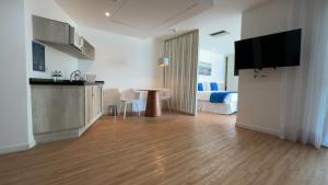 a living room with a kitchen and a room with a bed at Wyndham Rio Barra in Rio de Janeiro