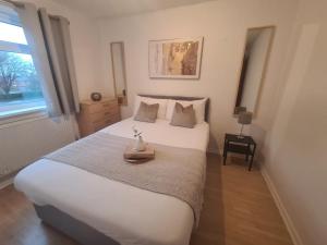 En eller flere senge i et værelse på Cosy 3 bed