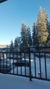 un grupo de autos estacionados en un estacionamiento cubierto de nieve en Apartman Miki, en Vlašić 2 fotos más