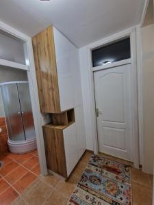 Baño con puerta blanca y alfombra en Apartman Miki, en Vlašić