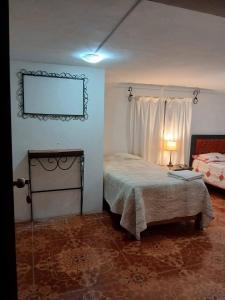 a bedroom with a bed and a frame on the wall at Casa Corazao in Urubamba
