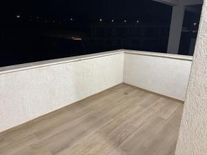 a balcony with a wooden floor and a view of the city at Bimat HaTzafon in Qiryat Shemona