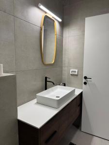 Un baño con un lavabo blanco y un espejo. en Bimat HaTzafon, en Kiryat Shemona