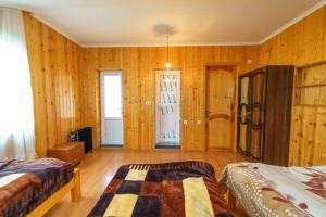 Guest House Nukri في Danisparauli: غرفة نوم بجدران خشبية وسريرين ونافذة