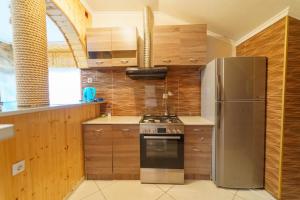 Guest House Nukri في Danisparauli: مطبخ مع موقد وثلاجة