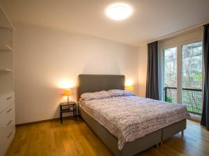 a bedroom with a bed and a large window at Central Bern Flat - Balcony & Bundeshaus View in Bern