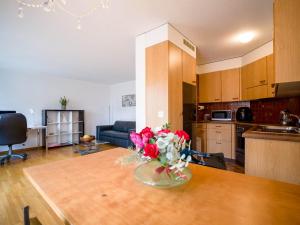 a vase of flowers on a table in a kitchen at Central Bern Flat - Balcony & Bundeshaus View in Bern