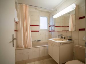 a bathroom with a sink and a bath tub at Central Bern Flat - Balcony & Bundeshaus View in Bern