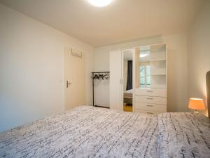 a white bedroom with a bed and a mirror at Central Bern Flat - Balcony & Bundeshaus View in Bern +29 photos