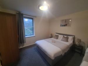 ein Schlafzimmer mit einem großen weißen Bett mit einem Fenster in der Unterkunft Quayside Apartment in Newcastle upon Tyne