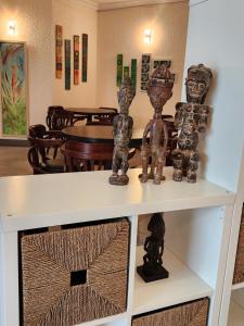 a white shelf with two sculptures on top of it at Kora Hotel Suites in Addis Ababa +8 photos