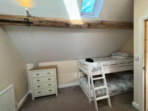 a small room with a bunk bed and a ladder at Woodland Forge - The Stables in Over Whitacre