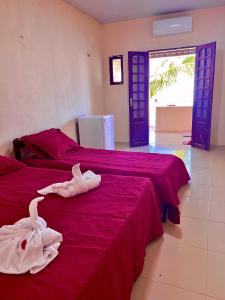 two beds with towels on them in a room at Pousada Brisa Mineira in Cascavel