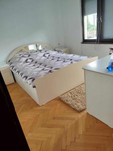 Villa Karetka Orizari في Orizari: سرير أبيض في غرفة ذات أرضية خشبية