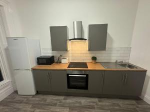 a kitchen with a sink and a refrigerator at Park Studios in Sunderland