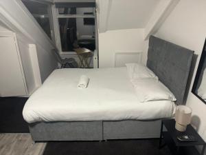 Un dormitorio con una cama grande con sábanas blancas. en Park Studios, en Sunderland