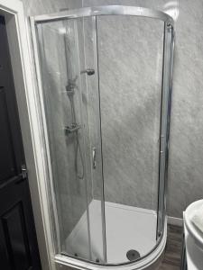 a shower with a glass door in a bathroom at Park Studios in Sunderland