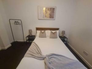 a bedroom with a large white bed with pillows at Pudding Chare Apartments in Newcastle upon Tyne
