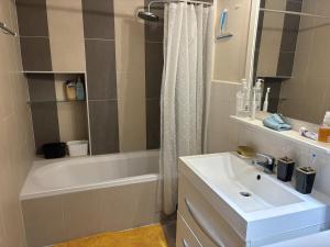 Un baño con lavabo, bañera y ducha. en Green room - Wifi - Centre ville - Cosy, en Annemasse