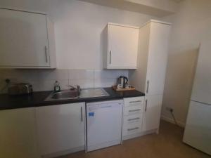 een keuken met witte kasten en een spoelbak bij Pudding Chare Apartments in Newcastle upon Tyne