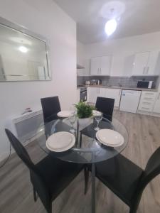 a glass table and chairs in a white kitchen at Pudding Chare Apartments in Newcastle upon Tyne +17 photos