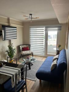 un soggiorno con un divano blu e un tavolo di Departamento en Centro de Temuco a Temuco Altre 4 foto